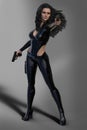 Gun toting Sci-Fi female enforcer with long hair dressed in black leather