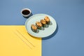 Gunkan sushi set in plate on coloured background with chopsticks and soy sauce. Minimal composition with japanesse food. Trendy