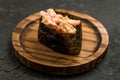 Gunkan sushi with spicy crab and rice on little circle board on dark stone table close up macro Royalty Free Stock Photo