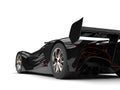 Gunmetal black racing super car with red details - rear wheel and tail closeup