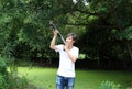 The gunner man standing long gun aiming top right sideways with white shirt and denim jean. Royalty Free Stock Photo