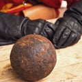 A gunner in vintage Swedish military clothing and cannon balls. Ancient military arsenal of the events of the Russian-Swedish war Royalty Free Stock Photo