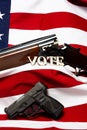 Guns with the letters vote in front of the American flag, vertical Royalty Free Stock Photo