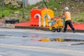 Street cleaner pushing yellow cart with cleaning supplies