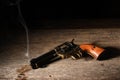 Landscape still life of gunslingers weapon still smoking as it lays on an old saloon floor Royalty Free Stock Photo