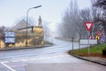 Vehicles moving on a winding country road through historical town on a foggy winter day. Guntersdorf, Lower Austria. Royalty Free Stock Photo