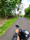 POV in over head shot from a motorbike driving on a village road.