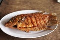 Gurame Bakar Madu, grilled gourami with honey and soy sauce. Served on white plate. Close up and selective focus.