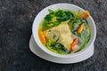 Gurame fish head soup or sup kepala ikan gurame with basil leaves, tomatoes, yellow curry, and chilli in a bowl. Indonesian food