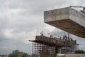 Labor and workers standing on a support for a bridge under construction with rebar support frame visible