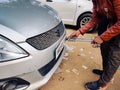 Man using a riveting locking tool to affix a tamper proof HSRP high security registeration plate to a maruti swift car