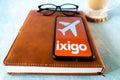 popular indian travel app ixigo on a mobile phone showing an orange cover and an aircraft for hotel, travel and IRCTC