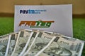 Fast Tag provided by PayTM Payment Bank on green grass along with currency notes