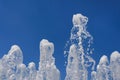 The gush of water of a fountain. Splash of water in the fountain on blue sky background Royalty Free Stock Photo