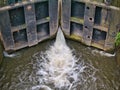 Gushing water leaking from wooden canal lock gates on the Leeds Liverpool Canal in Lancashire, England, UK