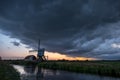 Stormclouds over a windmill in Holland at sunset Royalty Free Stock Photo