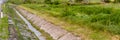 Gutter on the side of the road or with a ditch for water and a glade of green lawn along the road Royalty Free Stock Photo