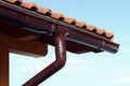 A wooden house with roof tiles and rain gutter.