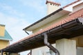 Guttering. Roof gutter pipeline sysem. House rain gutter with holders and downspout pipe