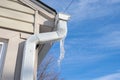 Gutters have frozen and icicles hang from the ice dams