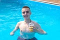 Guy with an amputated arm drinks a cocktail in swimming pool