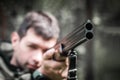 Guy armed with gun aim barrels of weapon at target close-up. Front view. Danger and crime concept. Shotgun in hands of hunter Royalty Free Stock Photo