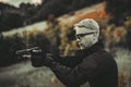 Instructor with gun in forest leads aiming and posing on camera Royalty Free Stock Photo