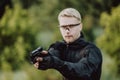 Instructor with gun in forest leads aiming and posing on camera Royalty Free Stock Photo