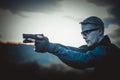Instructor with gun in forest leads aiming and posing on camera Royalty Free Stock Photo