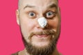 A guy with a beard with foam and gel on his face is preparing to shave in the morning at home on a colored background Royalty Free Stock Photo