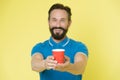 Guy beard and mustache holds paper cup of tea or coffee. Offer drink to you. Trainer experienced man care about water