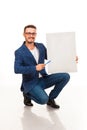 A guy with a beard posing with a white sign. Can be used for advertising, logo and business cards, contact phones, shares, etc.