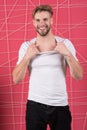 Guy bearded and attractive tearing off shirt. Man with bristle on happy face undressing, pink background. Man with beard Royalty Free Stock Photo