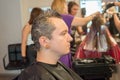 The guy in the beauty salon dyes gray hair in black. Barbershop concept