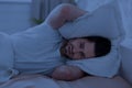 Guy in bed covering his head with pillow Royalty Free Stock Photo