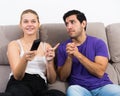 Guy begging girlfriend for TV remote Royalty Free Stock Photo