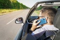 Guy behind wheel of car talking on phone and looking at road with an anxious look. Unsafe driving car. Talking on the phone behind Royalty Free Stock Photo