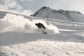 Guy on a snowboard sliding on a snowy mountain