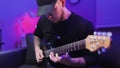 Guy in black shirt plays the electric guitar. Rock star plays. Close up view of the fingers on guitar riff