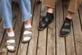 Guy in black socks and girl in white socks on the old wooden floor. both in sandals. close-up