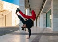 A guy in a black sweatshirt and red pants breakdancing on a sidewalk. Space to write Royalty Free Stock Photo