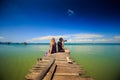 Guy Blond Girl Sit on Wooden Pier Photo Azure Sea in Tropics