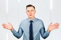 Guy businessman shrugs dressed in blue shirt and tie in bewilderment