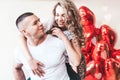 The guy carries the girl on his back against the background of red balloons Royalty Free Stock Photo