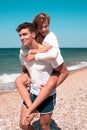 A guy carrying a girl on his back, at the beach Royalty Free Stock Photo