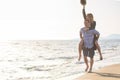 A guy carrying a girl on his back, at the beach, outdoors Royalty Free Stock Photo