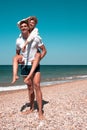 A guy carrying a girl on his back, at the beach Royalty Free Stock Photo