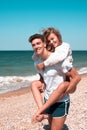 A guy carrying a girl on his back, at the beach Royalty Free Stock Photo