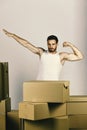 Man standing among boxes and pretending to fly like superhero