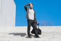 Guy in casual wear stand on stairs on blue sky, fashion. Man with bag, smartphone on steps on sunny outdoor. Macho ready for vacat Royalty Free Stock Photo